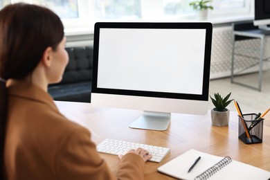 Photo of Woman working on computer at table in office