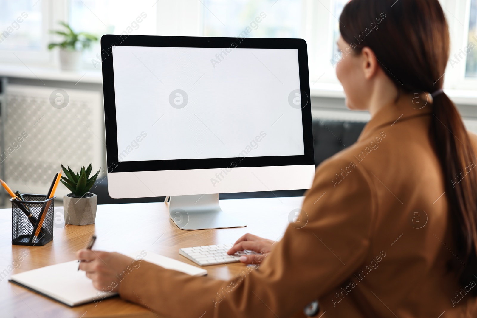 Photo of Woman working on computer at table in office