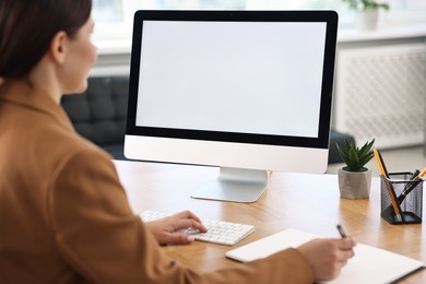 Photo of Woman working on computer at table in office