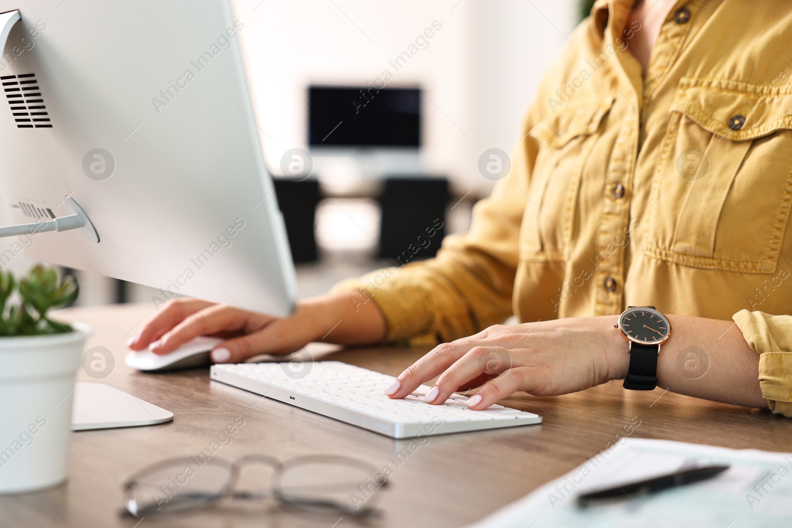 Photo of Woman working on computer at table in office, closeup