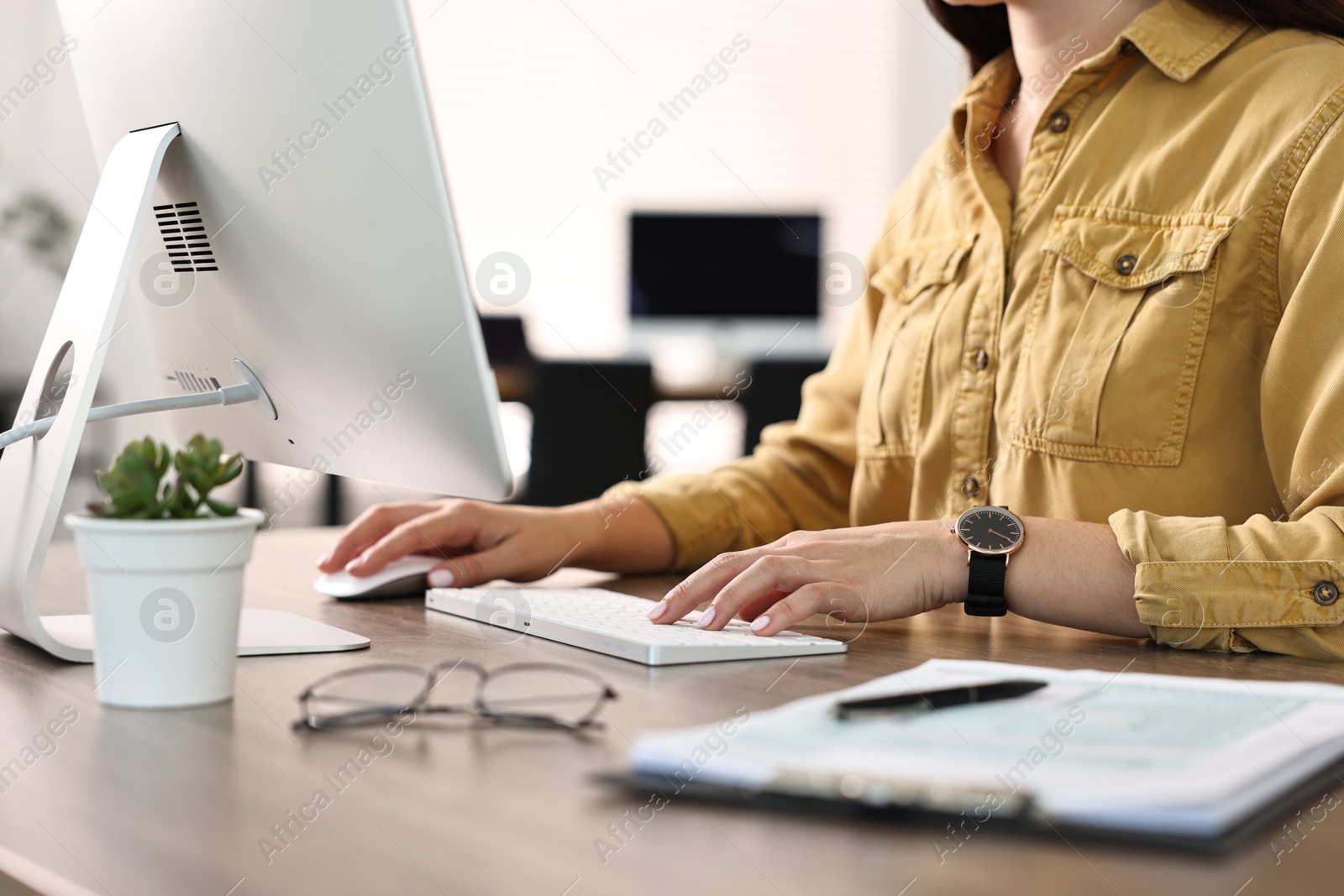 Photo of Woman working on computer at table in office, closeup