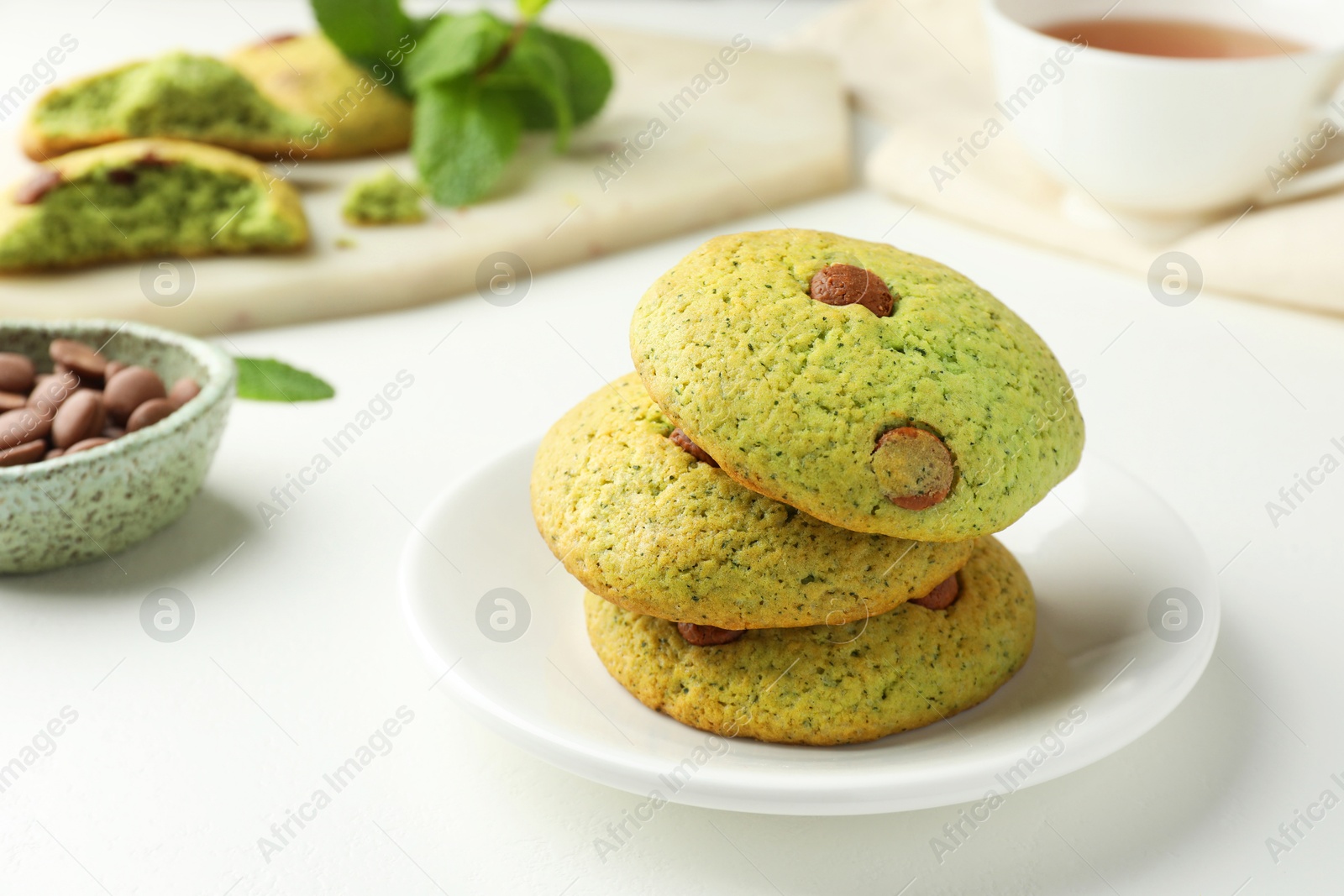 Photo of Delicious mint chocolate chip cookies on white table, closeup