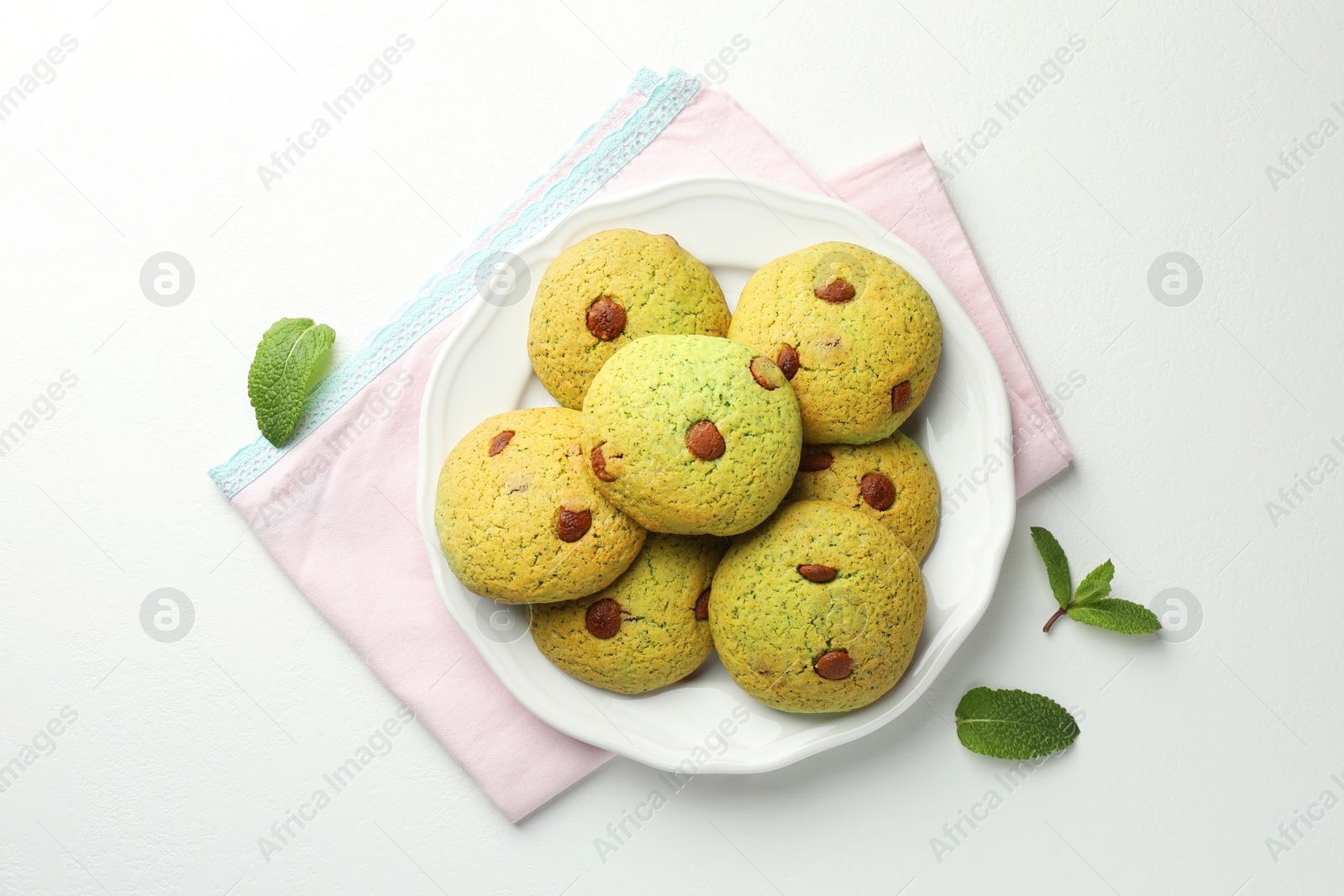 Photo of Delicious mint chocolate chip cookies on white table, top view