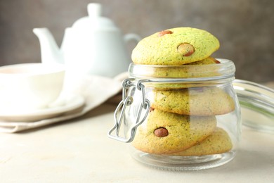 Photo of Delicious mint chocolate chip cookies in jar on light table, closeup. Space for text