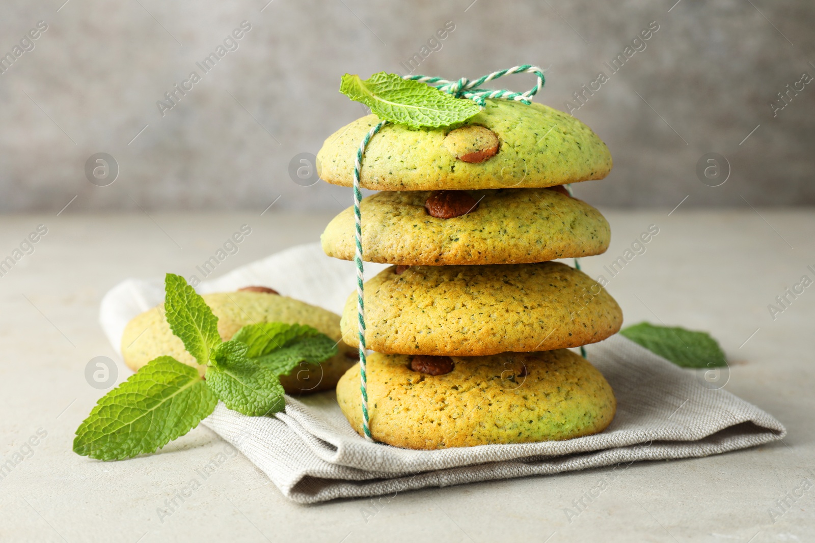 Photo of Delicious mint chocolate chip cookies on light table, closeup