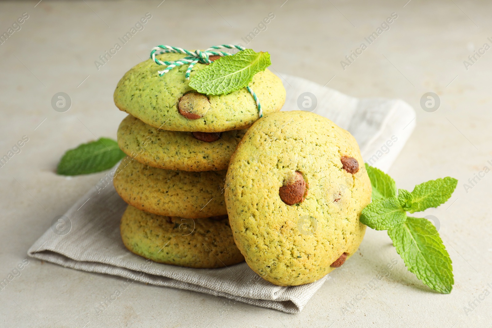 Photo of Delicious mint chocolate chip cookies on light table, closeup