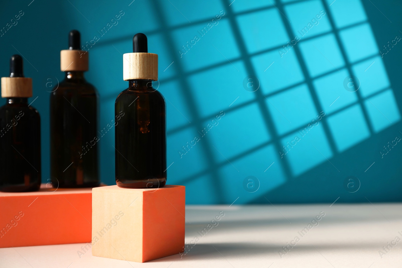 Photo of Bottles of cosmetic product on color background, space for text