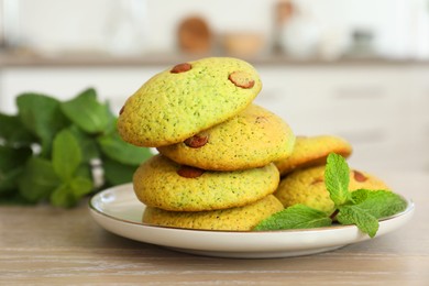 Photo of Delicious mint chocolate chip cookies on wooden table, closeup