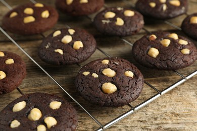 Photo of Tasty chocolate cookies with hazelnuts on wooden table, closeup