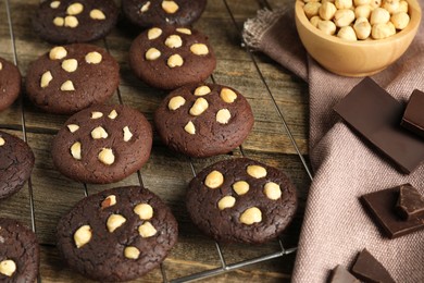 Photo of Tasty chocolate cookies with hazelnuts on wooden table, closeup