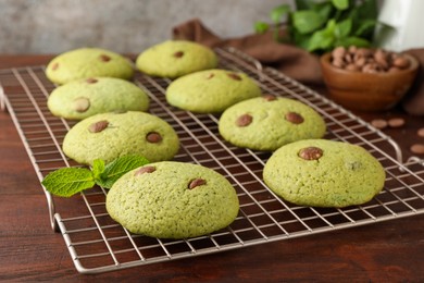 Photo of Delicious mint chocolate chip cookies on wooden table, closeup