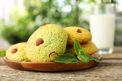 Photo of Delicious mint chocolate chip cookies on wooden table, closeup