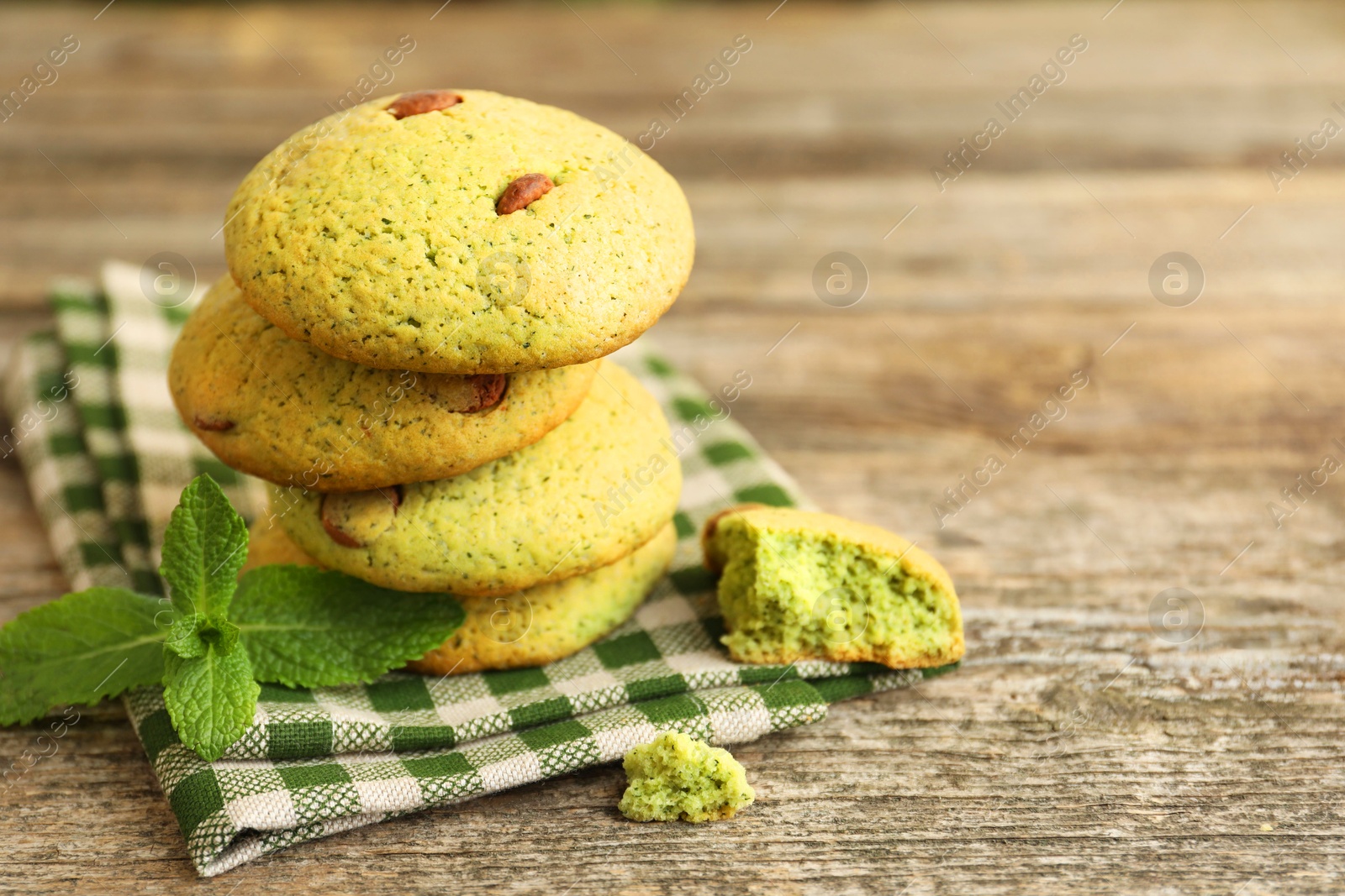 Photo of Delicious mint chocolate chip cookies on wooden table, closeup. Space for text