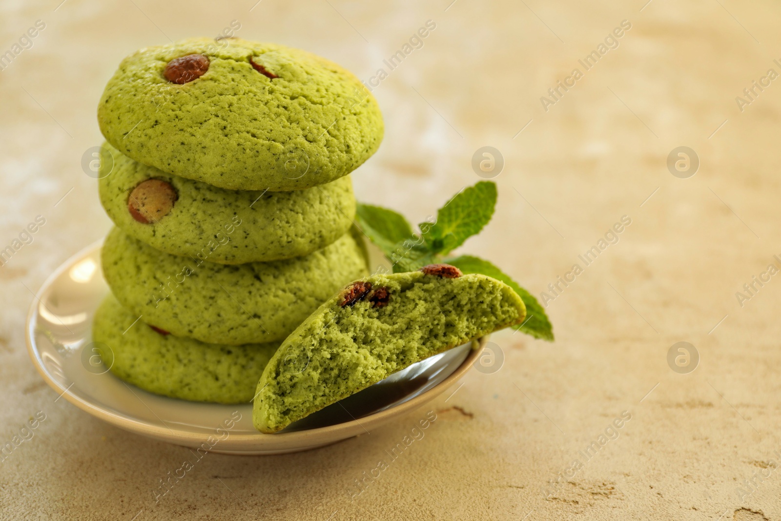 Photo of Delicious mint chocolate chip cookies on light table, closeup. Space for text