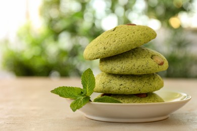 Photo of Delicious mint chocolate chip cookies on light table, closeup