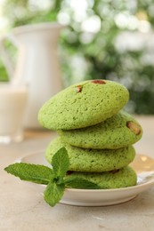 Photo of Delicious mint chocolate chip cookies on light table, closeup