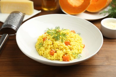 Photo of Delicious pumpkin risotto on wooden table, closeup