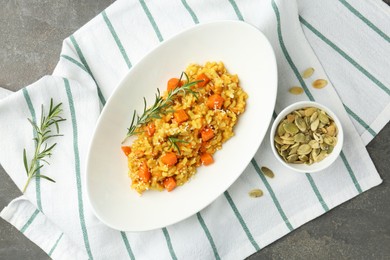 Photo of Delicious pumpkin risotto with rosemary on grey table, flat lay