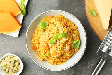 Photo of Delicious pumpkin risotto on grey table, flat lay
