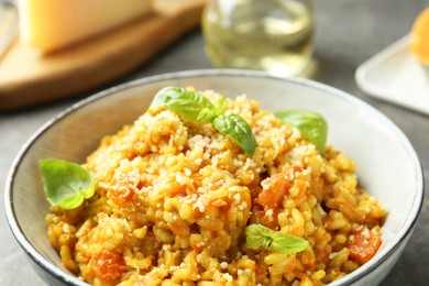 Photo of Delicious pumpkin risotto with basil on table, closeup