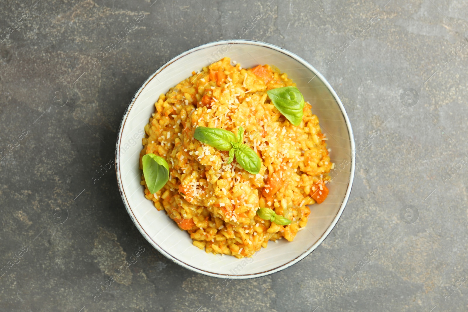 Photo of Delicious pumpkin risotto on grey table, top view