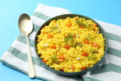Photo of Delicious pumpkin risotto served on light blue table