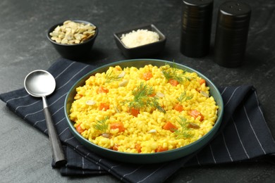 Photo of Delicious pumpkin risotto served on black table