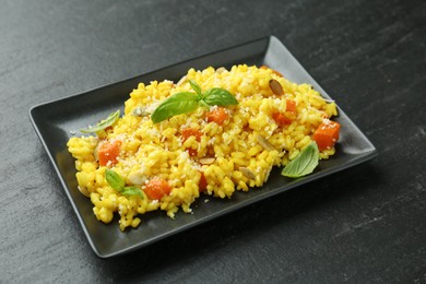 Photo of Delicious pumpkin risotto on black table, closeup