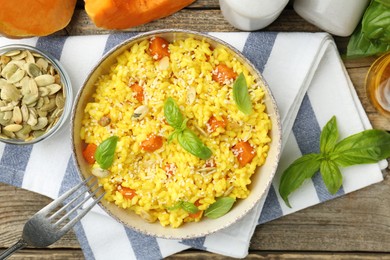 Photo of Delicious pumpkin risotto served on wooden table, flat lay