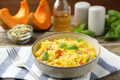 Photo of Delicious pumpkin risotto served on wooden table, closeup