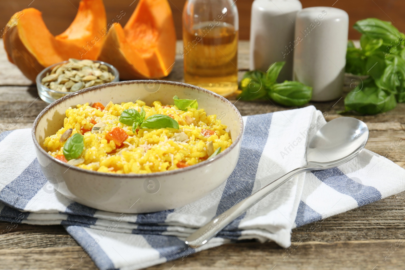 Photo of Delicious pumpkin risotto served on wooden table, closeup