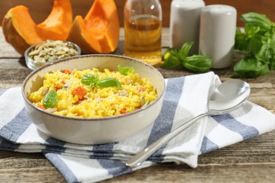 Photo of Delicious pumpkin risotto served on wooden table, closeup