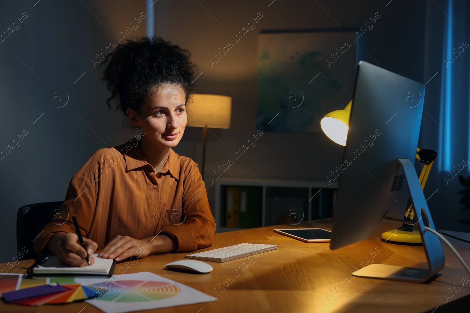 Photo of Designer working on computer indoors at night