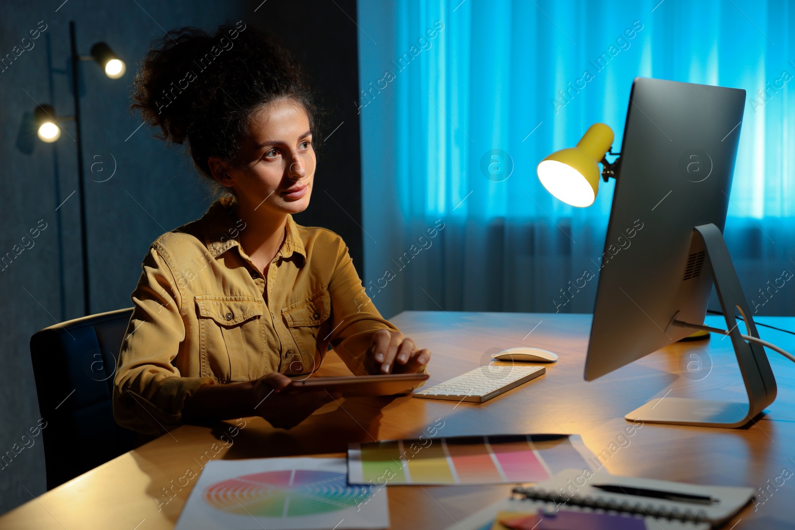 Photo of Designer with tablet working indoors at night