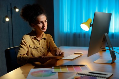 Photo of Designer with tablet working indoors at night