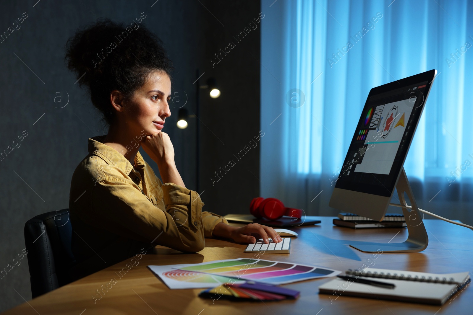 Photo of Designer working on computer indoors at night