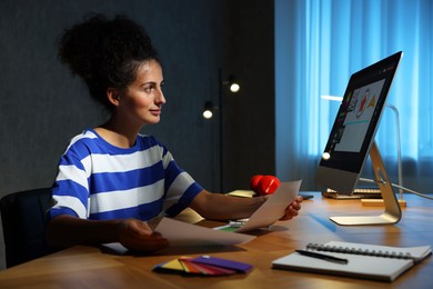 Photo of Designer with color palette working indoors at night