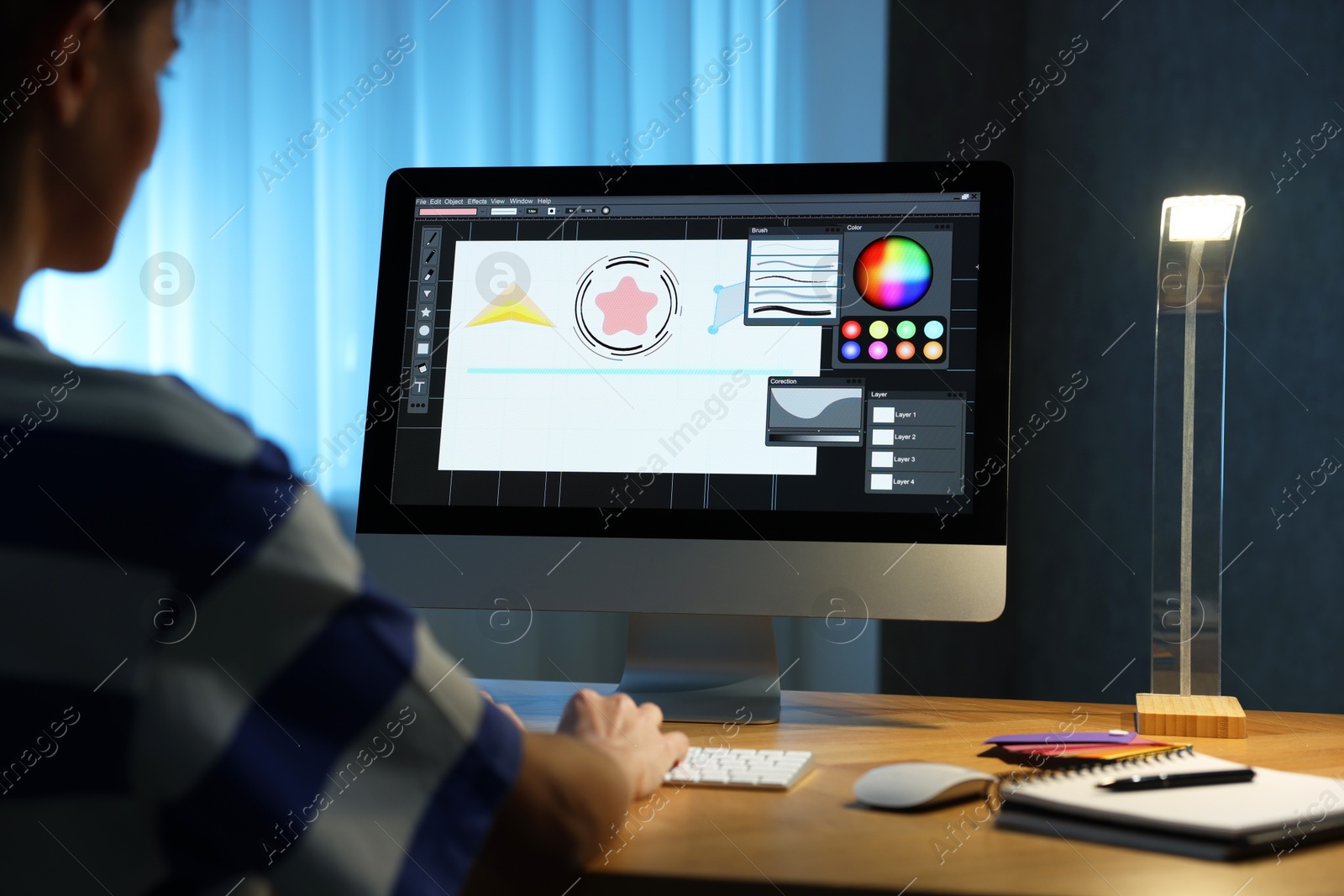 Photo of Designer working on computer indoors at night, closeup