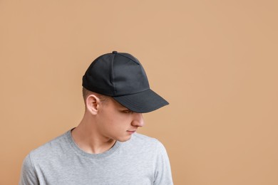 Photo of Man in stylish baseball cap on beige background. Mockup for design