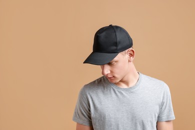 Man in stylish baseball cap on beige background. Mockup for design