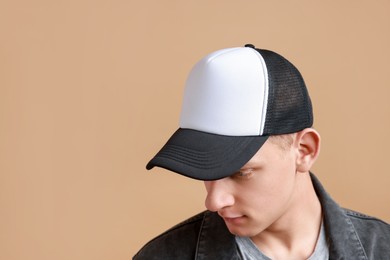 Photo of Man in stylish baseball cap on beige background. Mockup for design