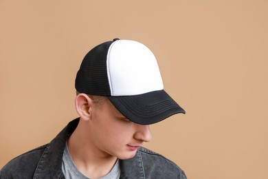 Photo of Man in stylish baseball cap on beige background. Mockup for design