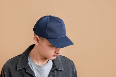 Photo of Man in stylish baseball cap on beige background. Mockup for design