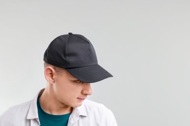 Photo of Man in stylish baseball cap on light grey background. Mockup for design