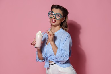 Photo of Happy pin-up woman with milk shake on pink background