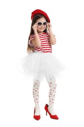 Photo of Stylish little girl wearing oversized high heeled shoes on white background