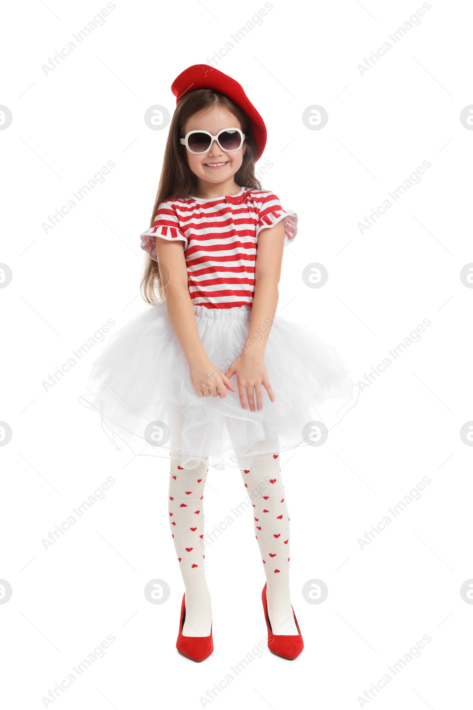 Photo of Stylish little girl wearing oversized high heeled shoes on white background