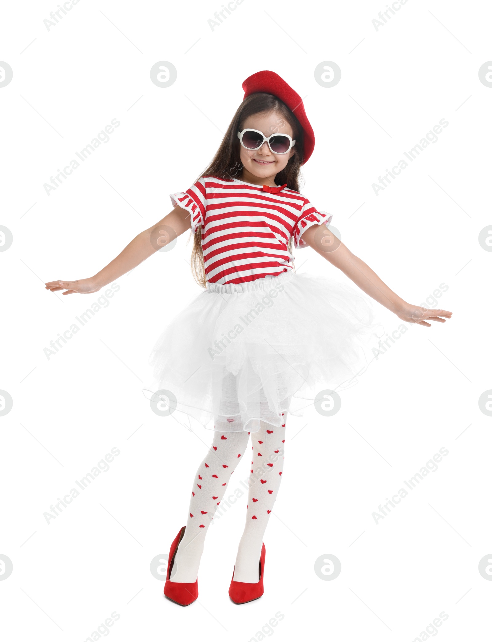 Photo of Stylish little girl wearing oversized high heeled shoes on white background