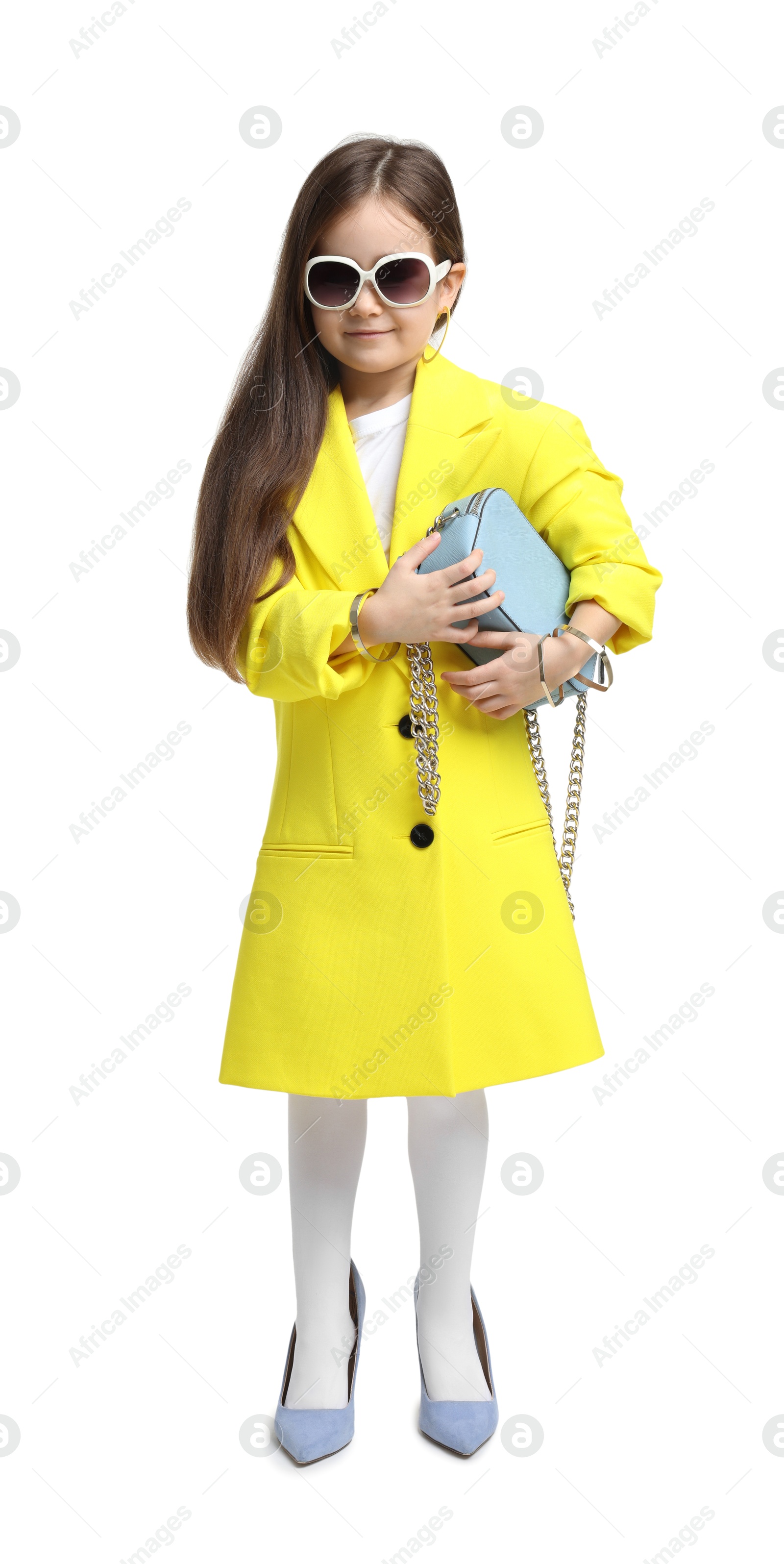 Photo of Stylish little girl wearing oversized high heeled shoes on white background