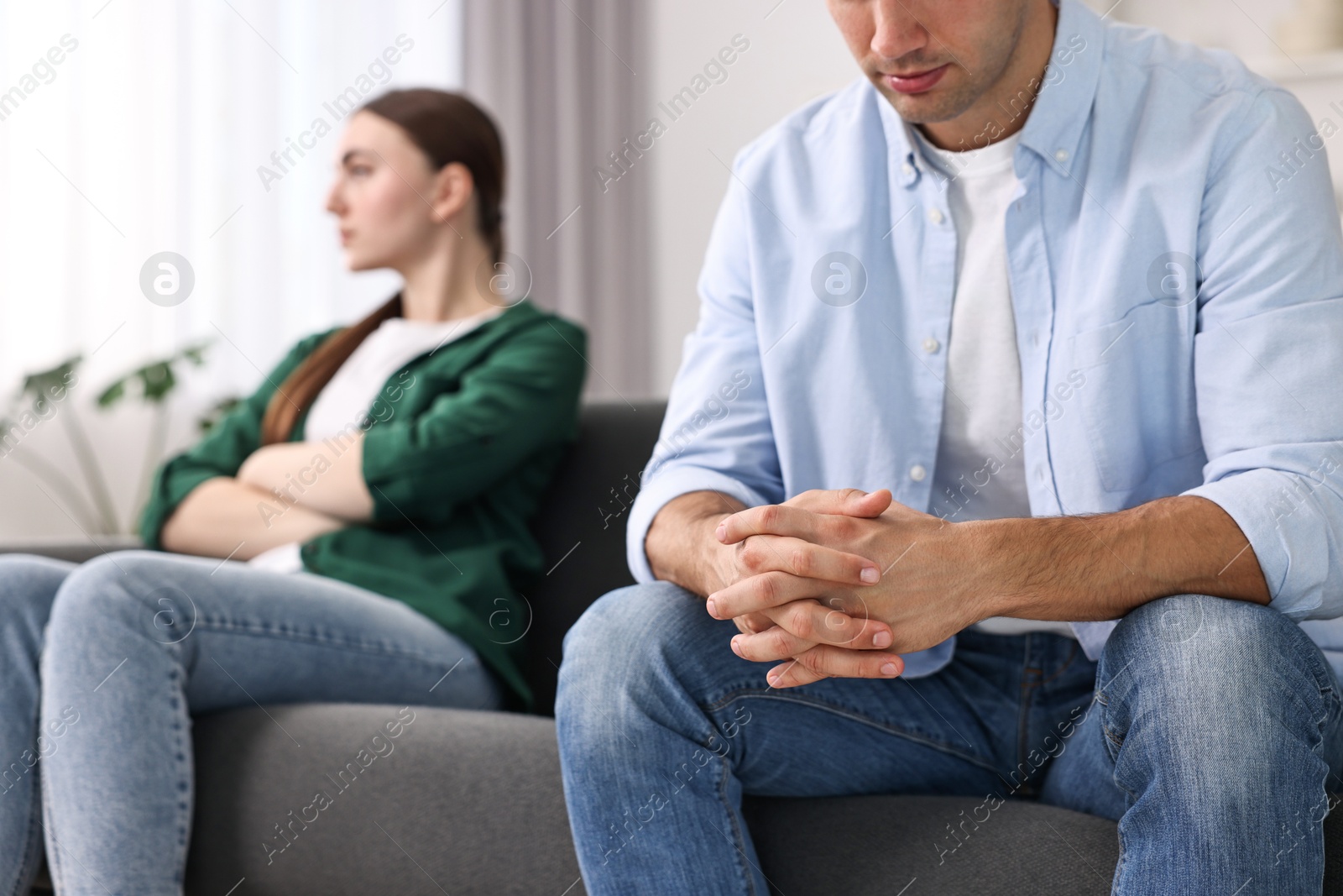 Photo of Offended couple ignoring each other at home, selective focus